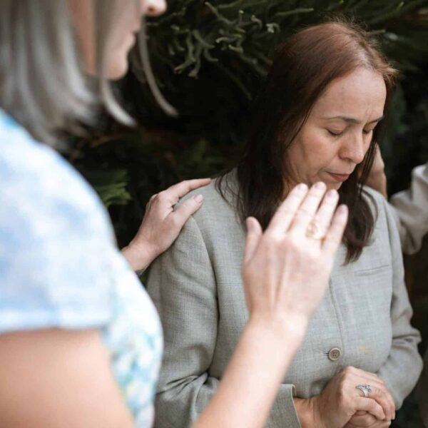 Three women in a heartfelt prayer gathering, emphasizing faith and community. praying with others