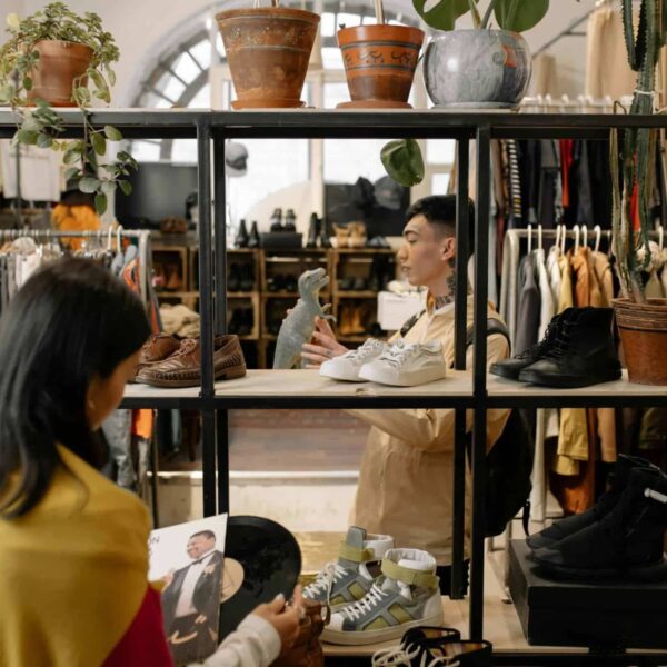 People browsing and selecting items in a stylish vintage clothing shop interior. second-hand shopping