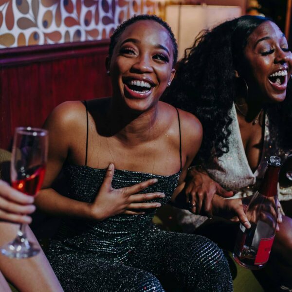 Joyful moment among friends enjoying drinks and laughter at a festive indoor party. love bombing friendships