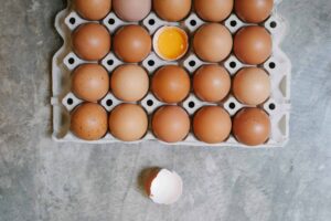 Top view of chicken eggs in rows in paper container placed on table for cooking. egg recall