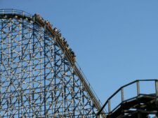 Experience the exhilarating thrill of a roller coaster ascending the steep peak at an amusement park. thrill seekers, roller coaster, roller coasters