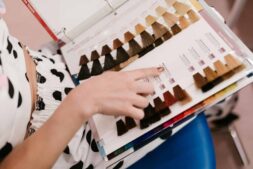 shampoo, colored hair, Woman selecting hair color samples in a salon, showcasing shades of brown and blonde.