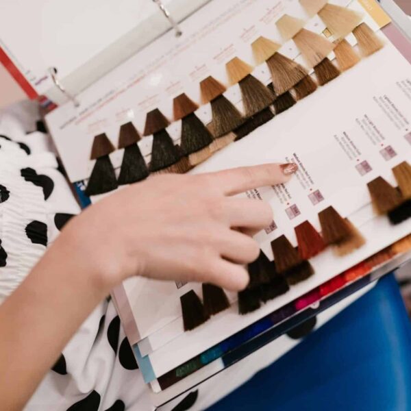 shampoo, colored hair, Woman selecting hair color samples in a salon, showcasing shades of brown and blonde.