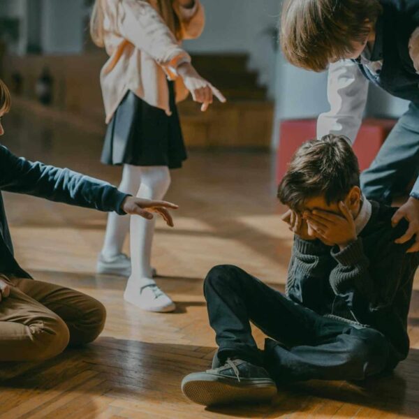 Group of kids bullying another child at school, signaling peer pressure and harassment. upstander