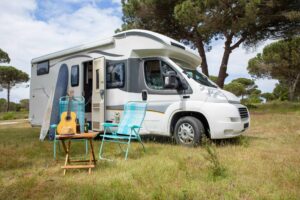 Explore the outdoor lifestyle with an RV, surfboards, and guitar in a serene Portuguese park. RV Parks