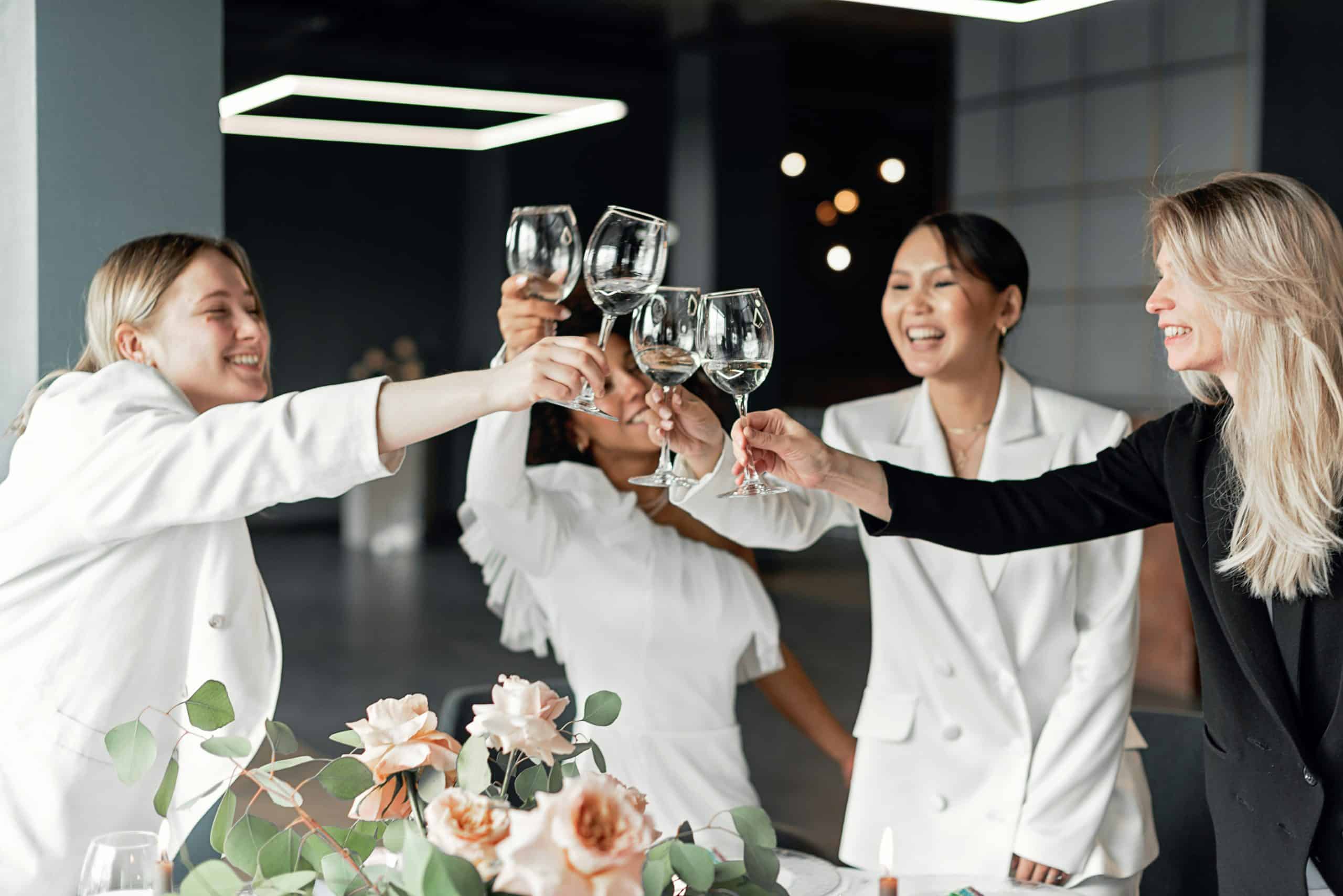 Two women celebrating long-distance friendships indoors, clinking wine glasses with joyful smiles during a toast. Photo by Mikhail Nilov via Pexels.