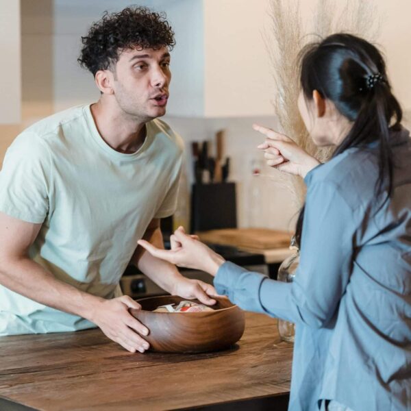 A couple engages in a heated discussion in a contemporary kitchen, highlighting relationship dynamics.