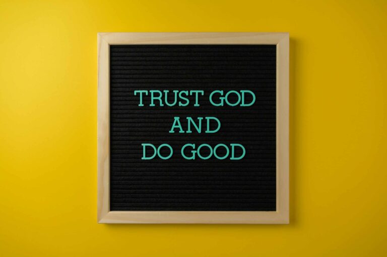 Inspirational message 'Trust God and Do Good' on a stylish black letter board with a vibrant yellow background. Proverbs 3