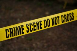 True-crime series concept image showing a close-up of yellow crime scene tape with “Do Not Cross” text in an outdoor setting. Photo by Kat Wilcox via Pexels.