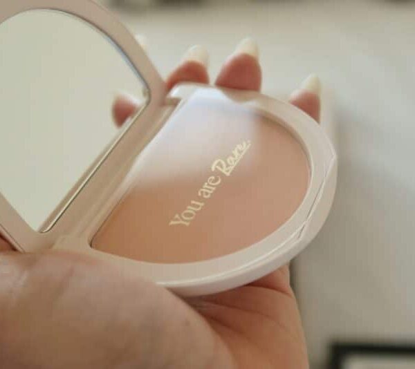 This photograph is of a compact. "You are Rare" is written inside." Rare Beauty is a makeup company begun by Selena Gomez.