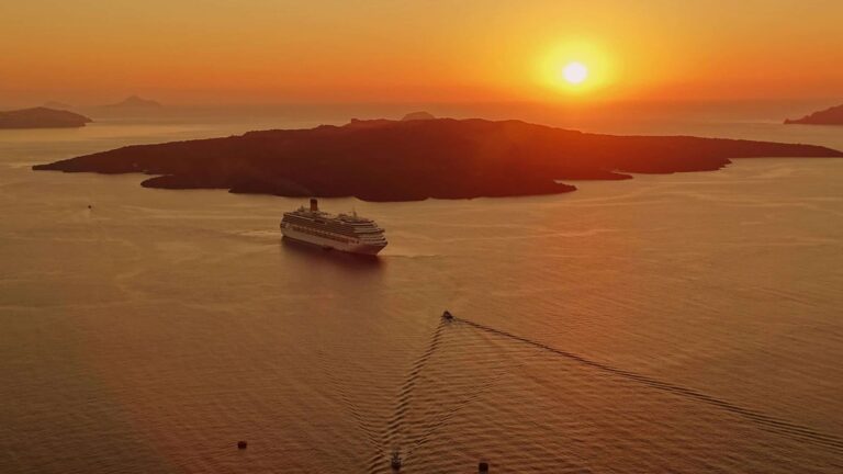 Solo travelers, solo travel, cruise line, cruise ship. A breathtaking sunset view of a cruise ship near the island of Santorini, Greece.