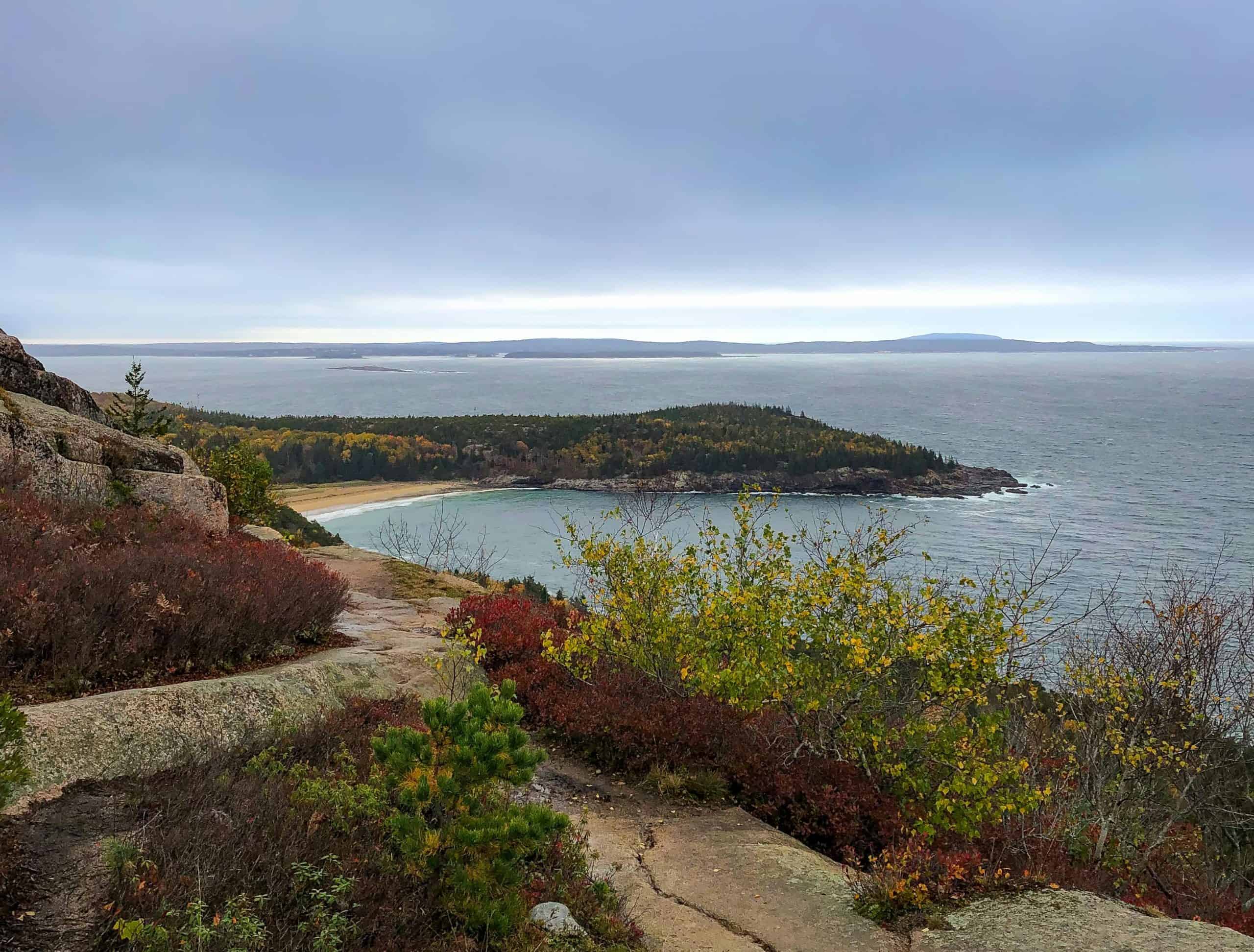 A breathtaking view of Bar Harbor, Maine, with fall foliage and the ocean.