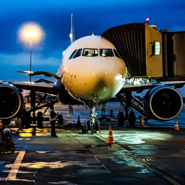 travel experts, A commercial airplane on the runway at Bengaluru airport during night with a blue sky backdrop. cheap flights