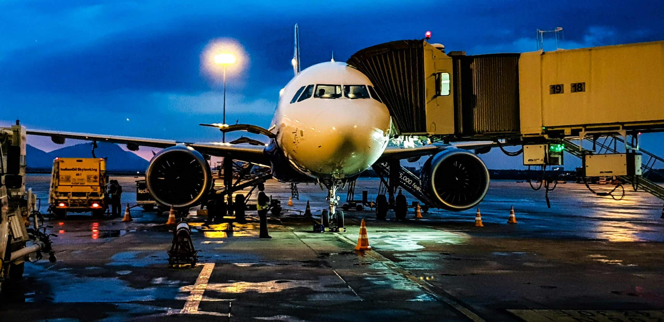 travel experts, A commercial airplane on the runway at Bengaluru airport during night with a blue sky backdrop. cheap flights