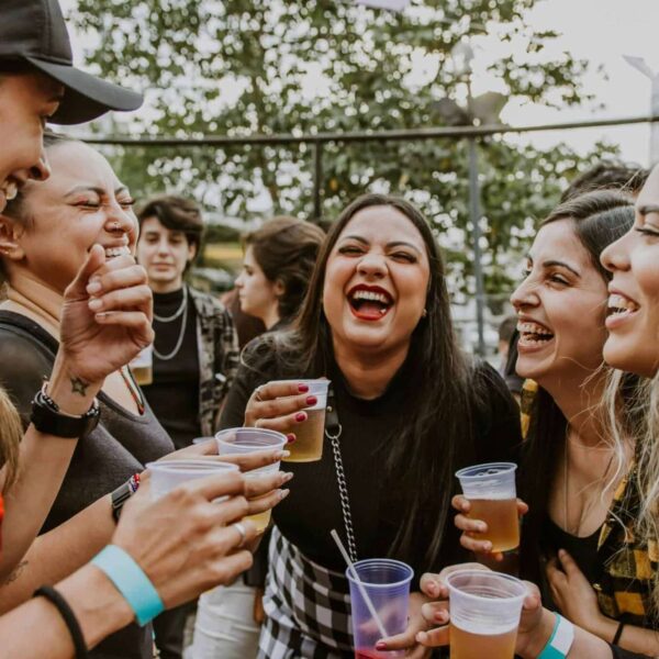 breweries, seasonal beer, Group of young women laughing and enjoying drinks outdoors in São Paulo.