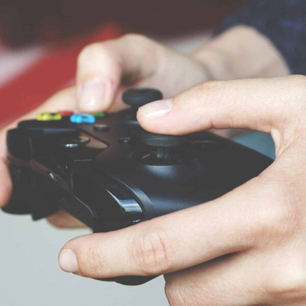 Close-up image of hands gripping an Xbox game controller depicting immersive gaming technology.