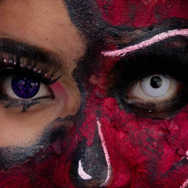 Dramatic close-up of Halloween SFX makeup with detailed face painting and colored contacts. Halloween contact lenses