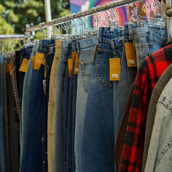 A rack of vintage jeans and shirts at an outdoor flea market in Los Angeles, CA. / anti-American sentiment