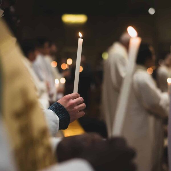People holding candles in a solemn religious ceremony in a Roman church. Daily devotion