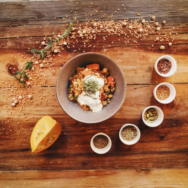 Healthy, pumpkin spice, Top view of a rustic vegetarian bowl and spices placed on a wooden table, ideal for recipe inspiration.