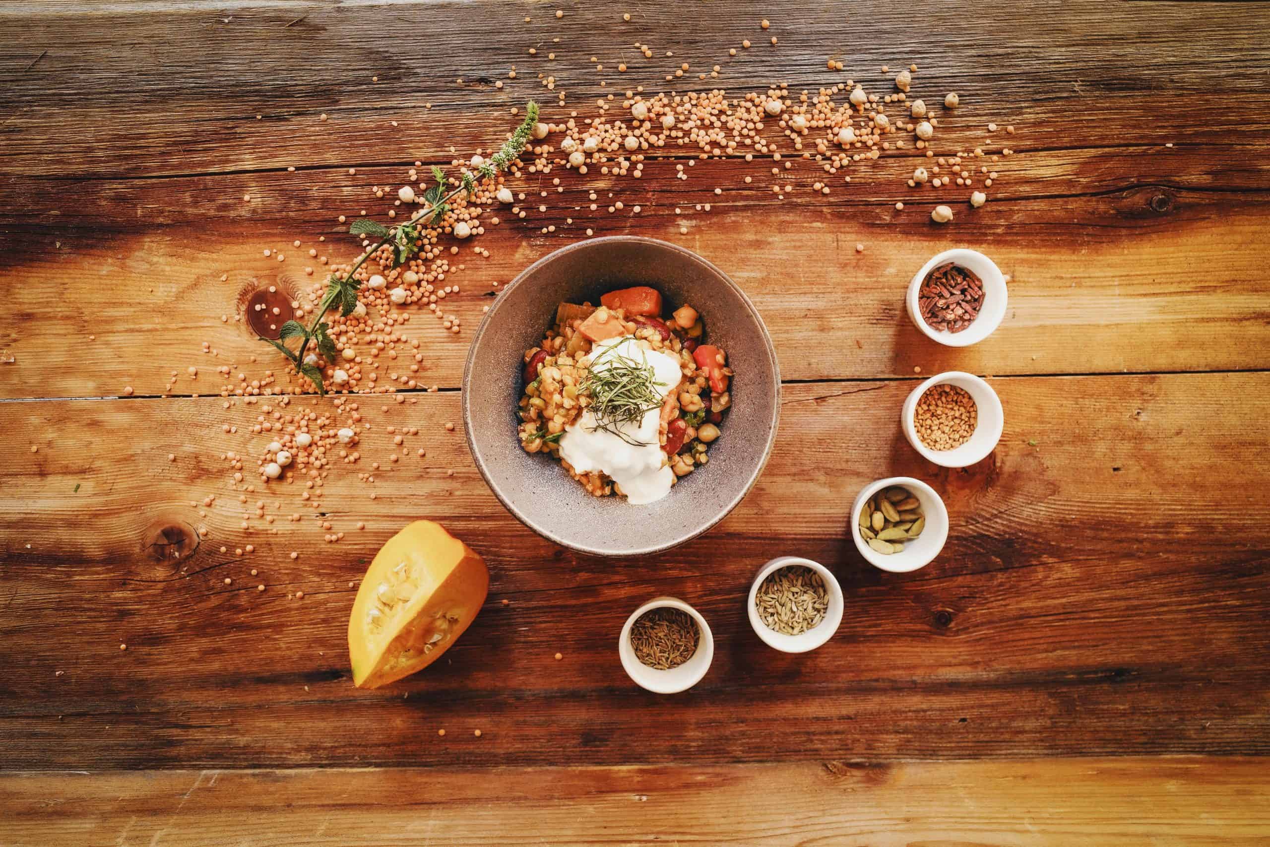 Healthy, pumpkin spice, Top view of a rustic vegetarian bowl and spices placed on a wooden table, ideal for recipe inspiration.