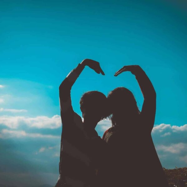 Emotional Intelligence, Silhouette of a couple creating a heart shape with their arms in a romantic outdoor setting.