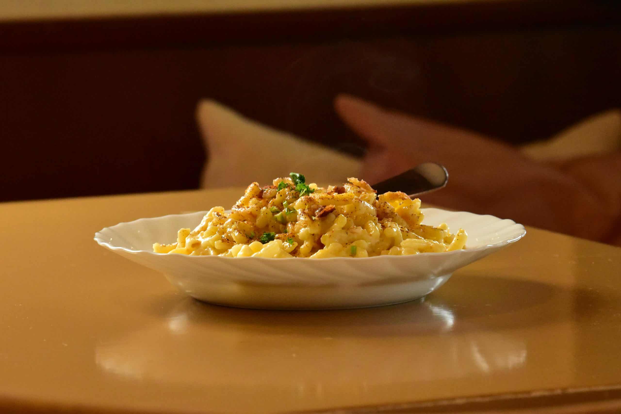 Close-up shot of gourmet mac and cheese on a table, perfect for food blogs.
