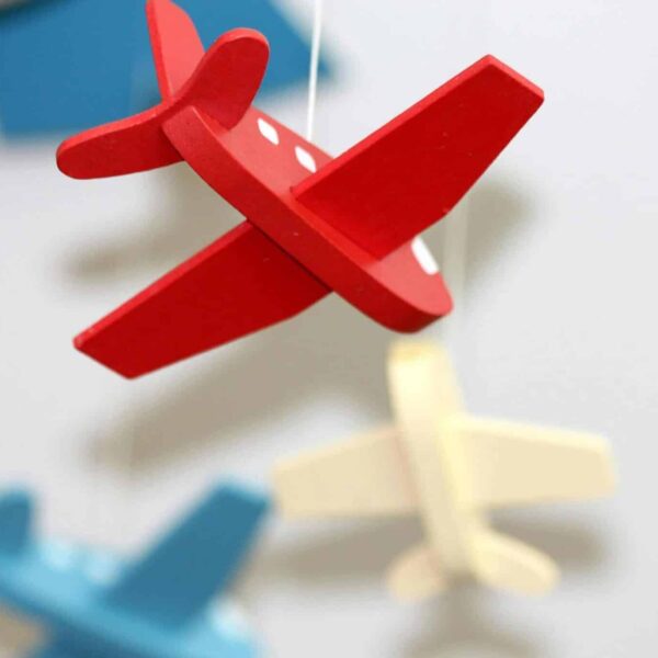 flying, young children, A close-up of colorful wooden airplane toys in a mobile, perfect for nursery décor.