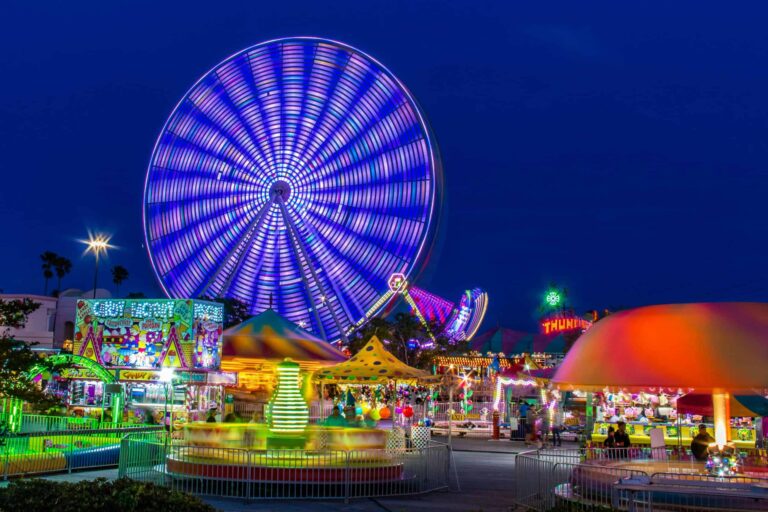 Autumn, love life, Brightly lit amusement park with a spinning Ferris wheel at night.