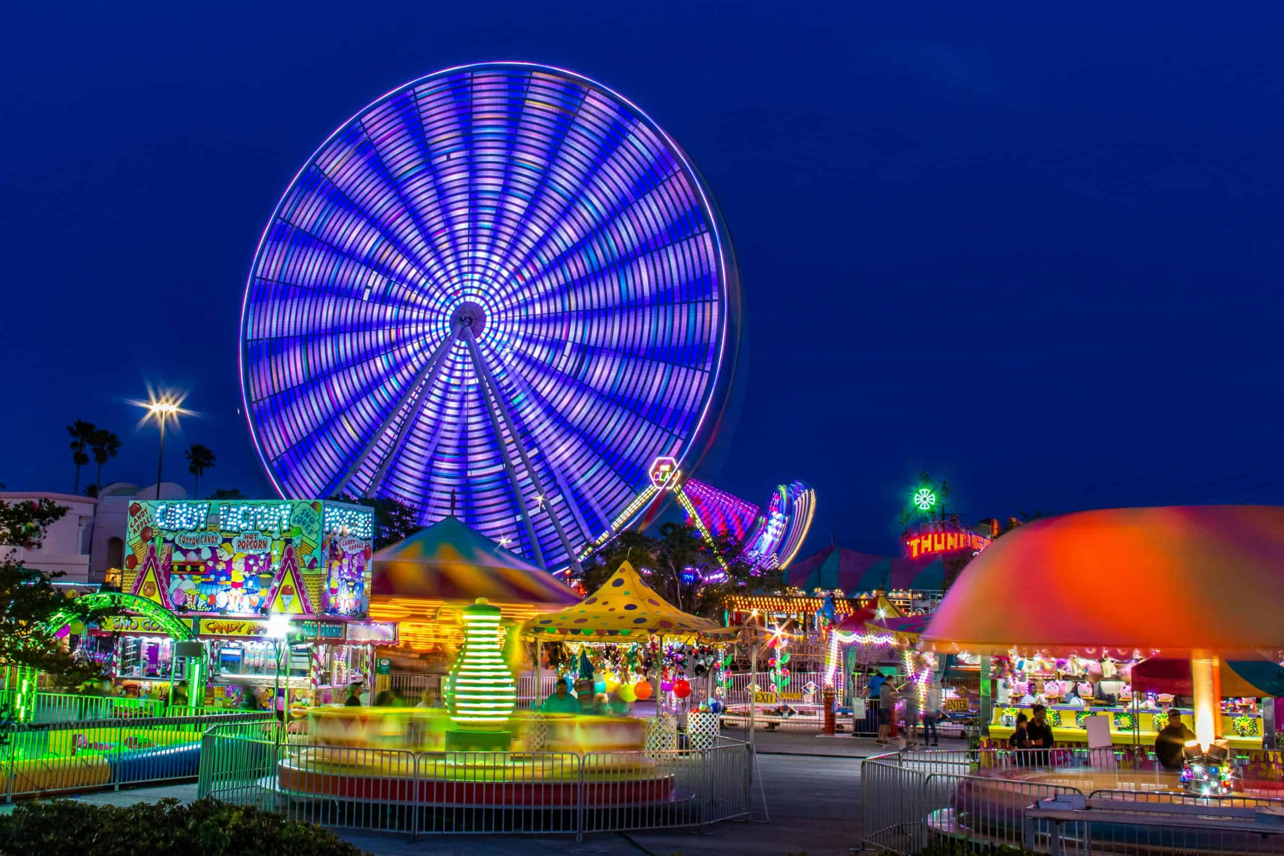 Autumn, love life, Brightly lit amusement park with a spinning Ferris wheel at night.