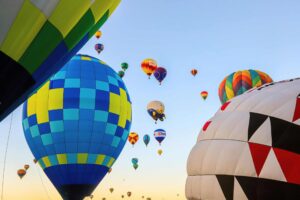 A vibrant display of hot air balloons soaring at dawn in Albuquerque, New Mexico. Balloon Fiesta