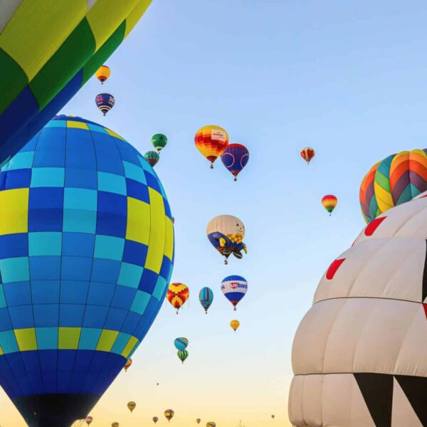 A vibrant display of hot air balloons soaring at dawn in Albuquerque, New Mexico. Balloon Fiesta