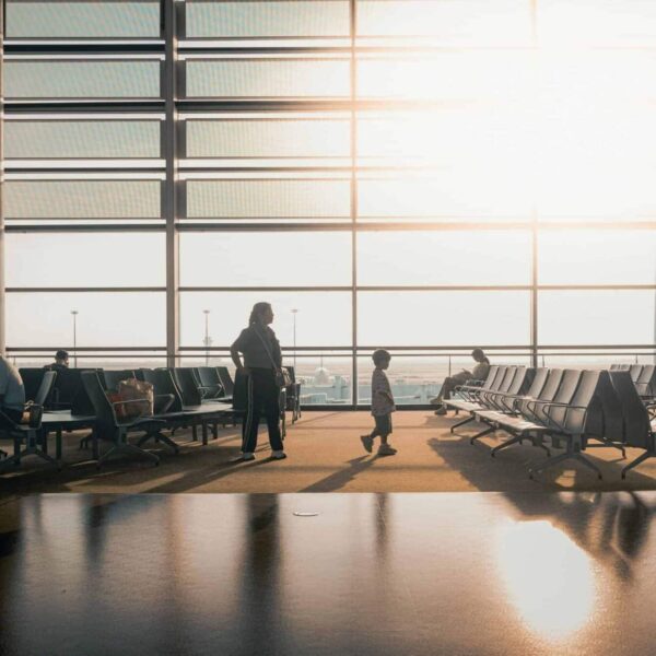 Families on the Fly, Silhouettes of travelers in a sunlit airport terminal in Shanghai, China.