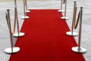 Emmy Awards, Red carpet entrance with stanchions on a tiled outdoor surface, perfect for events.