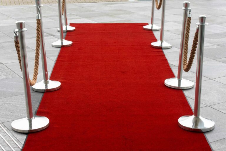 Emmy Awards, Red carpet entrance with stanchions on a tiled outdoor surface, perfect for events.