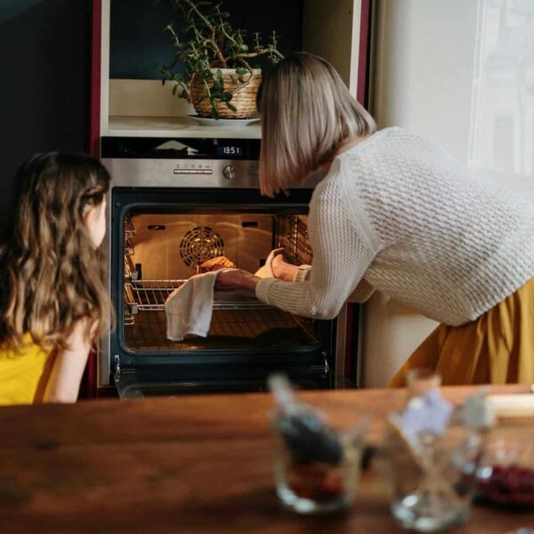 A mother and daughter baking a cake in a cozy kitchen setting, enhancing family time. air fryer vs oven, cooking, better options