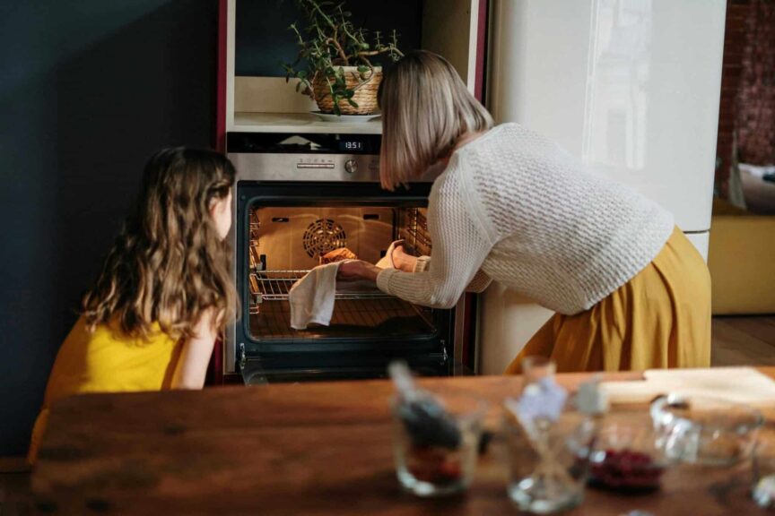 A mother and daughter baking a cake in a cozy kitchen setting, enhancing family time. air fryer vs oven, cooking, better options