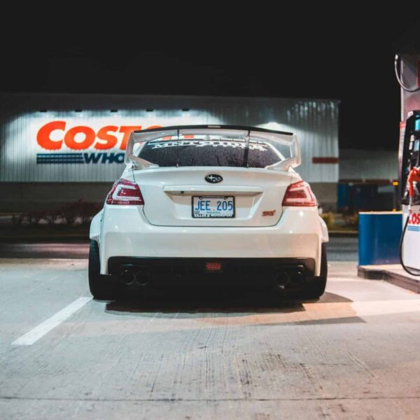 Costco, Contemporary white car parked near pump on fuel station at night in city