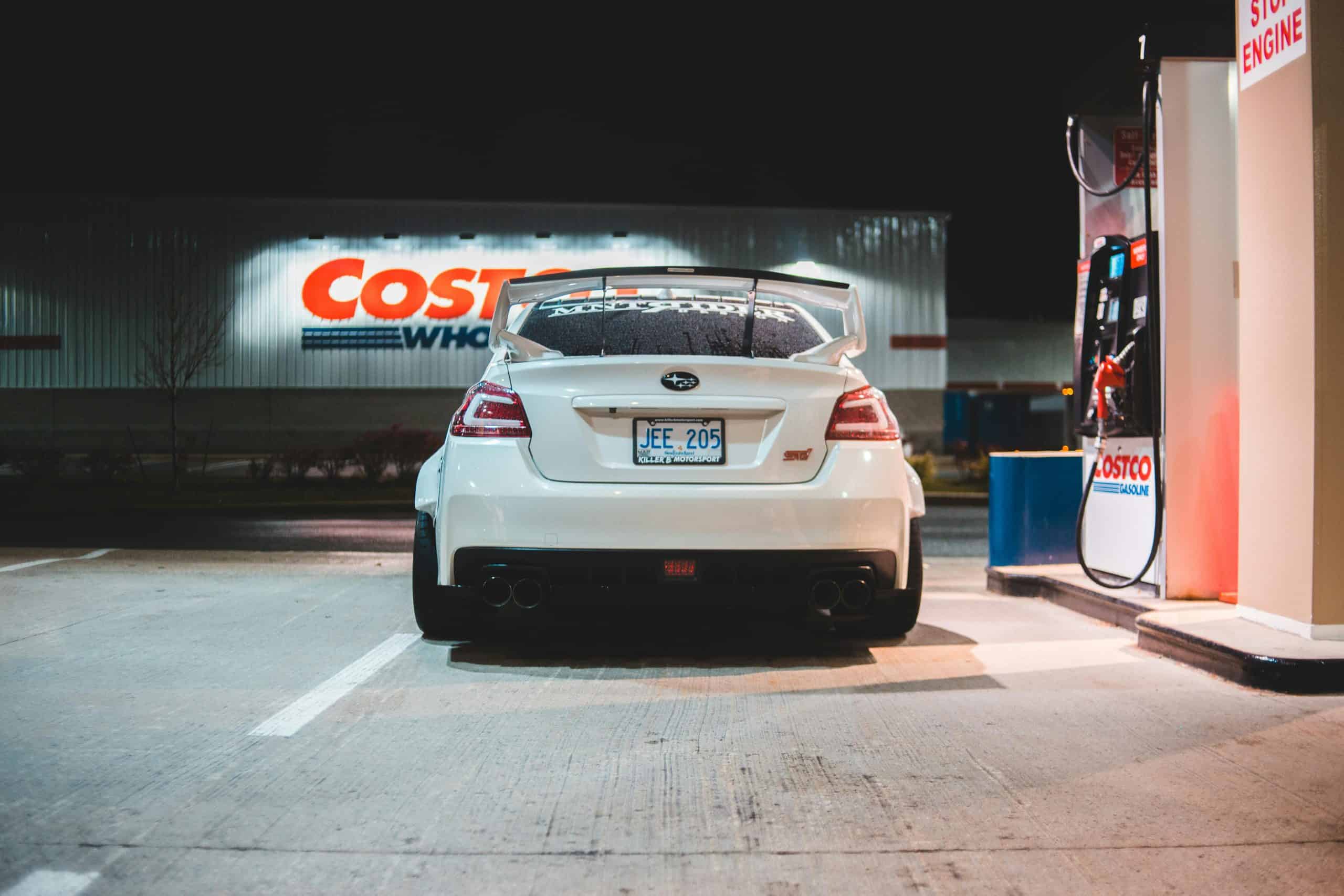 Costco, Contemporary white car parked near pump on fuel station at night in city