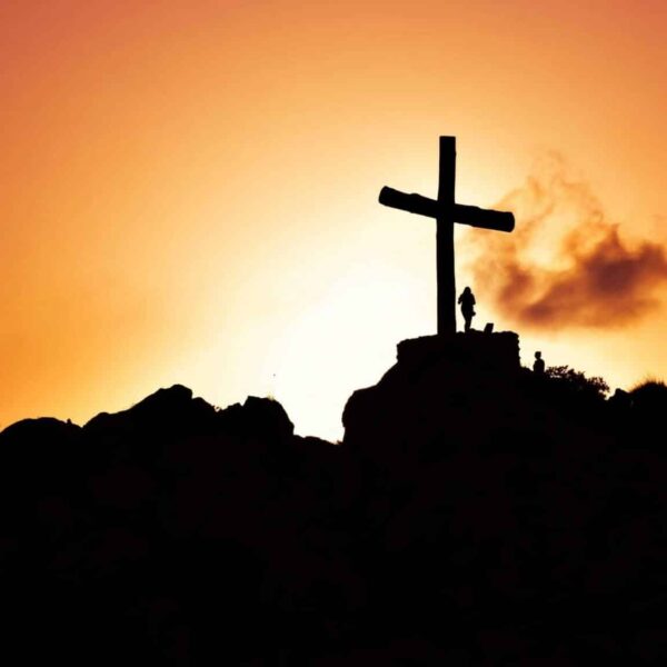 needs not being prioritized, Majestic silhouette of a cross on a hill during a vivid sunset, symbolizing spirituality.