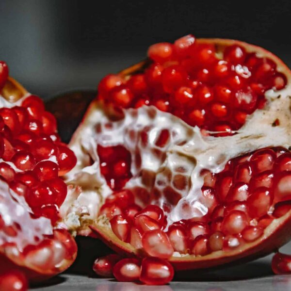 immune system, A close-up shot of a juicy pomegranate revealing vibrant red seeds and textured skin.