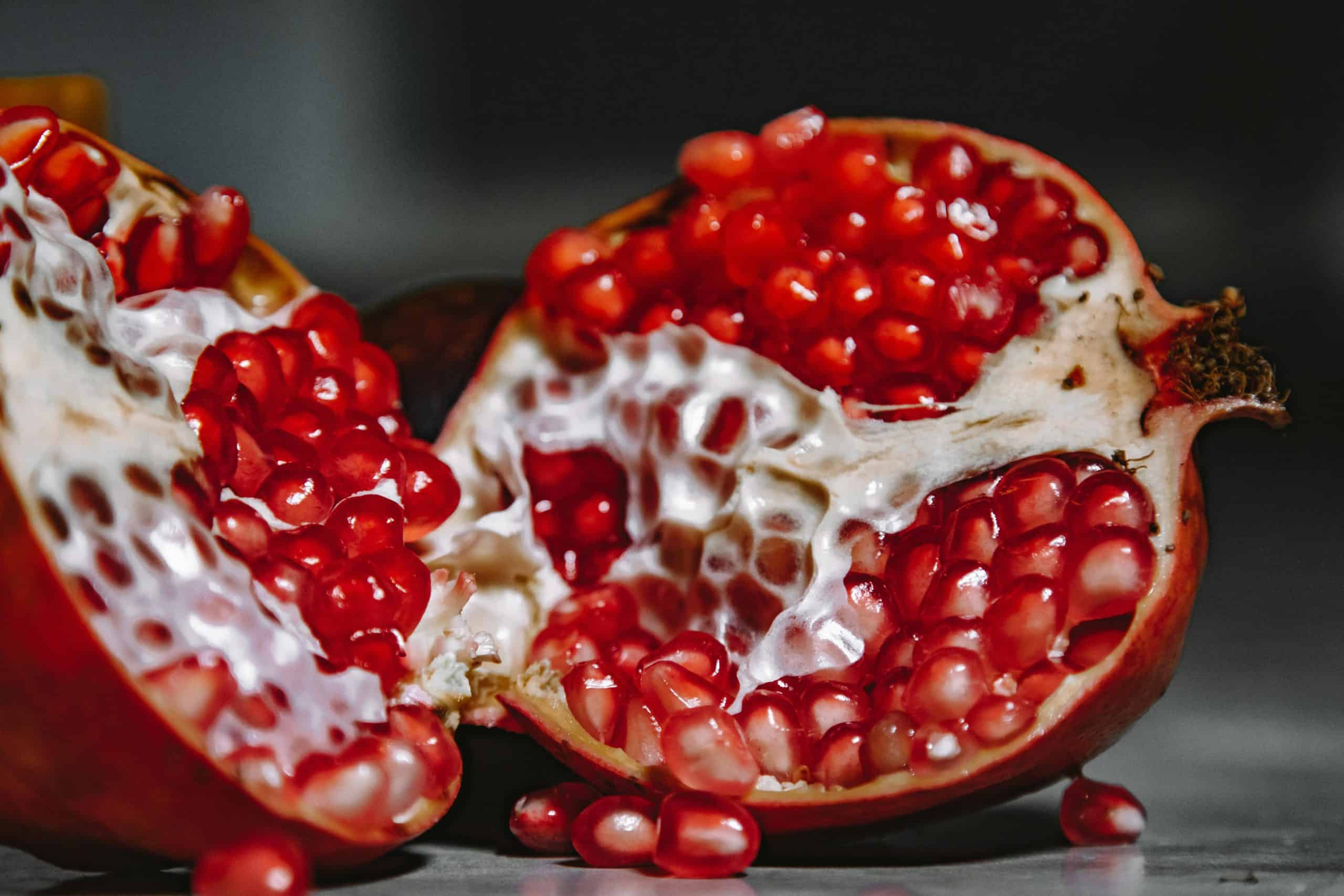 immune system, A close-up shot of a juicy pomegranate revealing vibrant red seeds and textured skin.