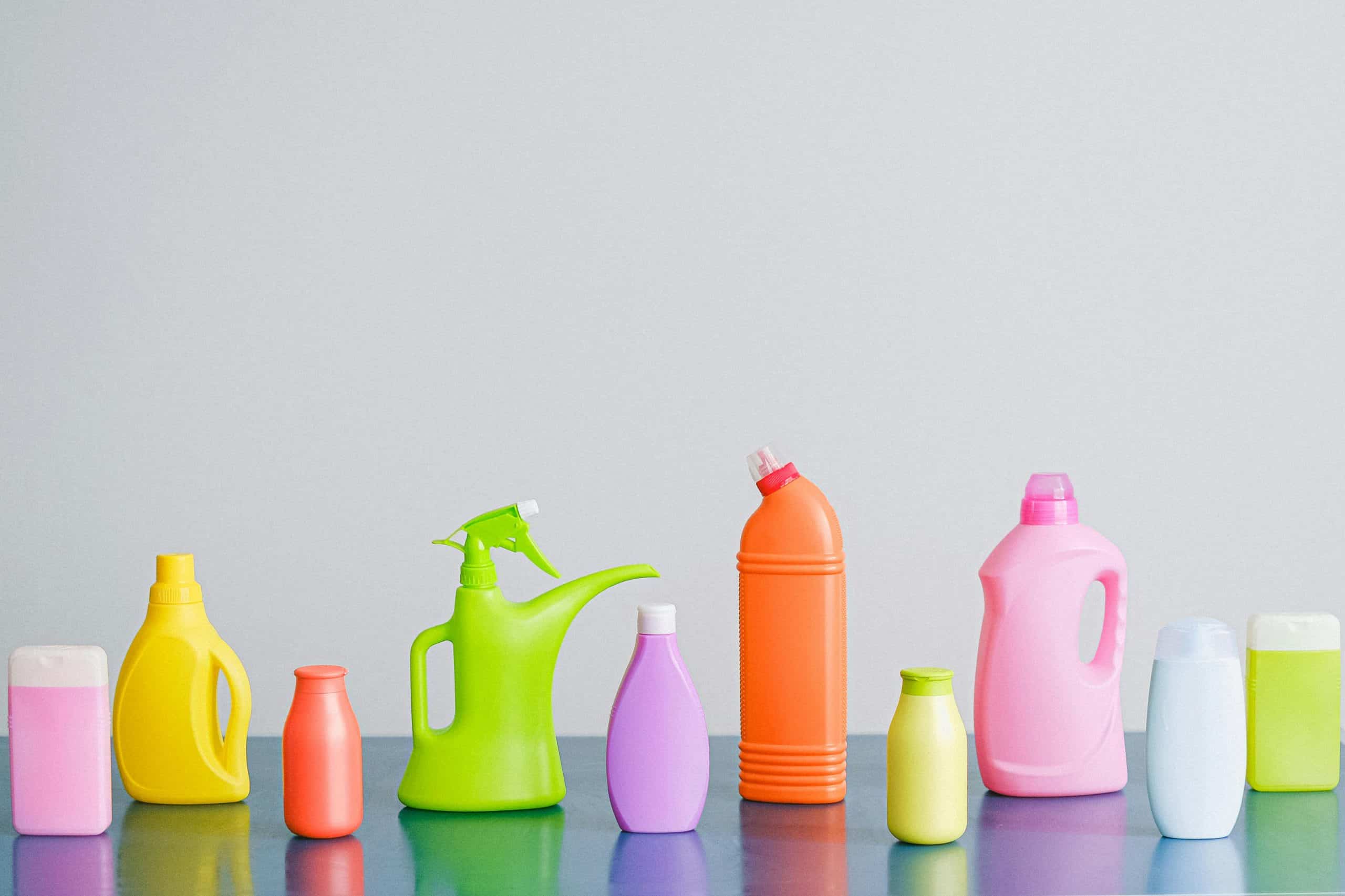 A vibrant assortment of cleaning product containers arranged on a reflective surface, perfect for household sanitation themes.