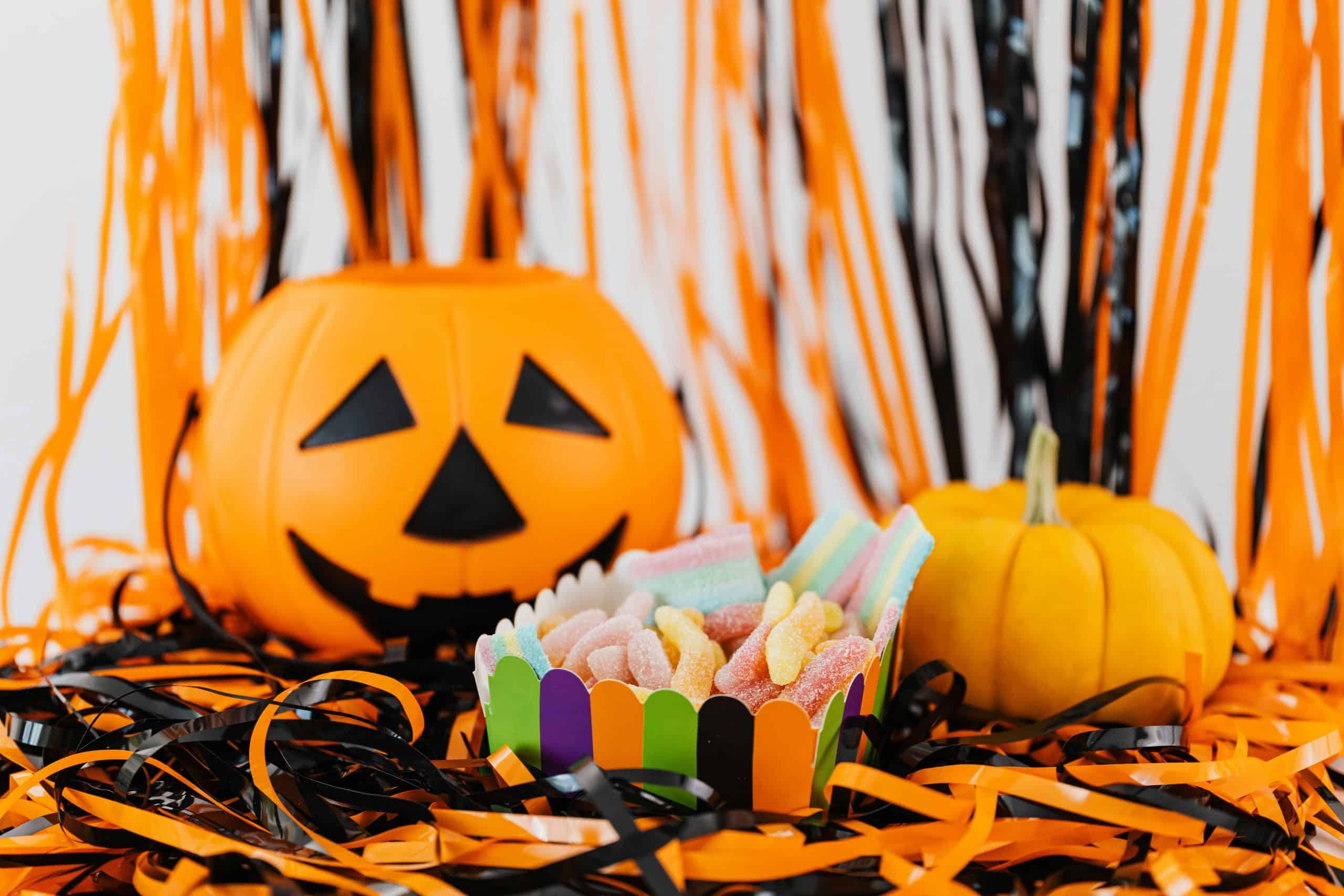 Vibrant Halloween display with a carved pumpkin, colorful candy, and festive decorations.