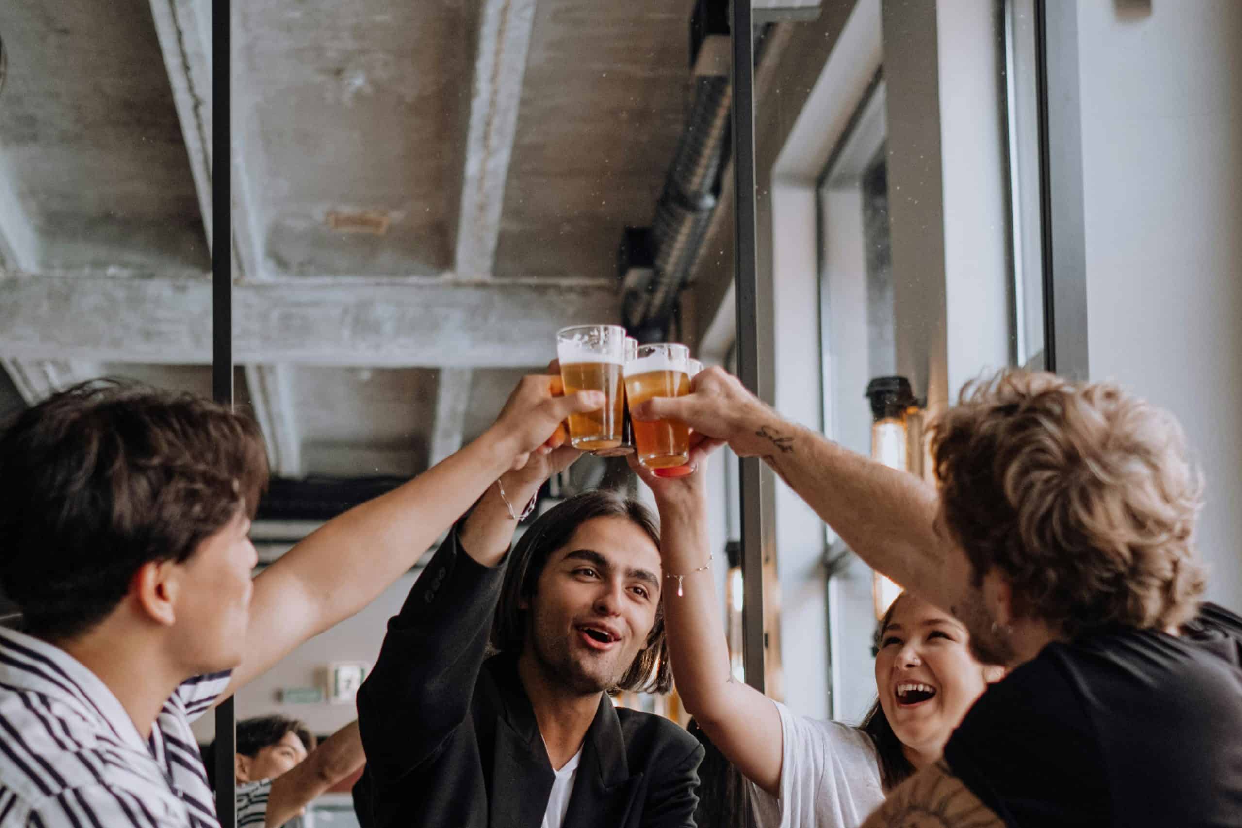 A group of young adults enjoying drinks and celebrating together in a trendy indoor bar.