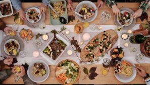 Dinner Party, Fall theme, Overhead shot of a vibrant dining table setup with pasta, salads, and decorative candles, capturing a festive gathering.