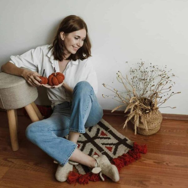 This is a photograph of a woman sitting on the floor. You can declutter your space before hosting fall holiday visitors.