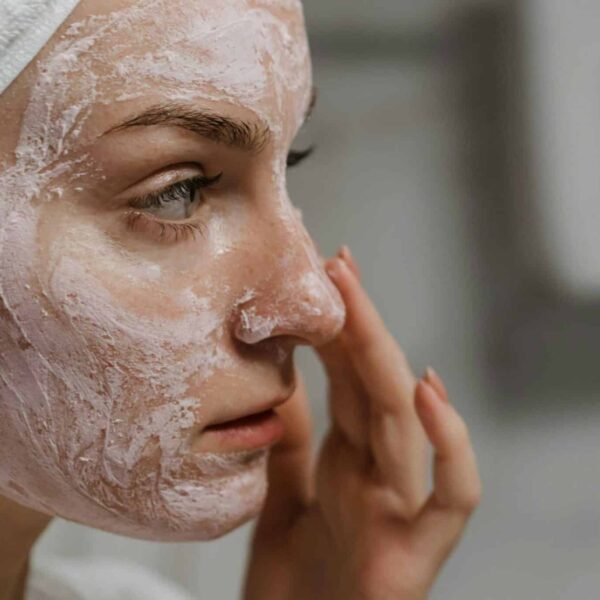 fall skincare - Close-up of a woman applying facial cream as part of her skin care routine, enhancing skin health.