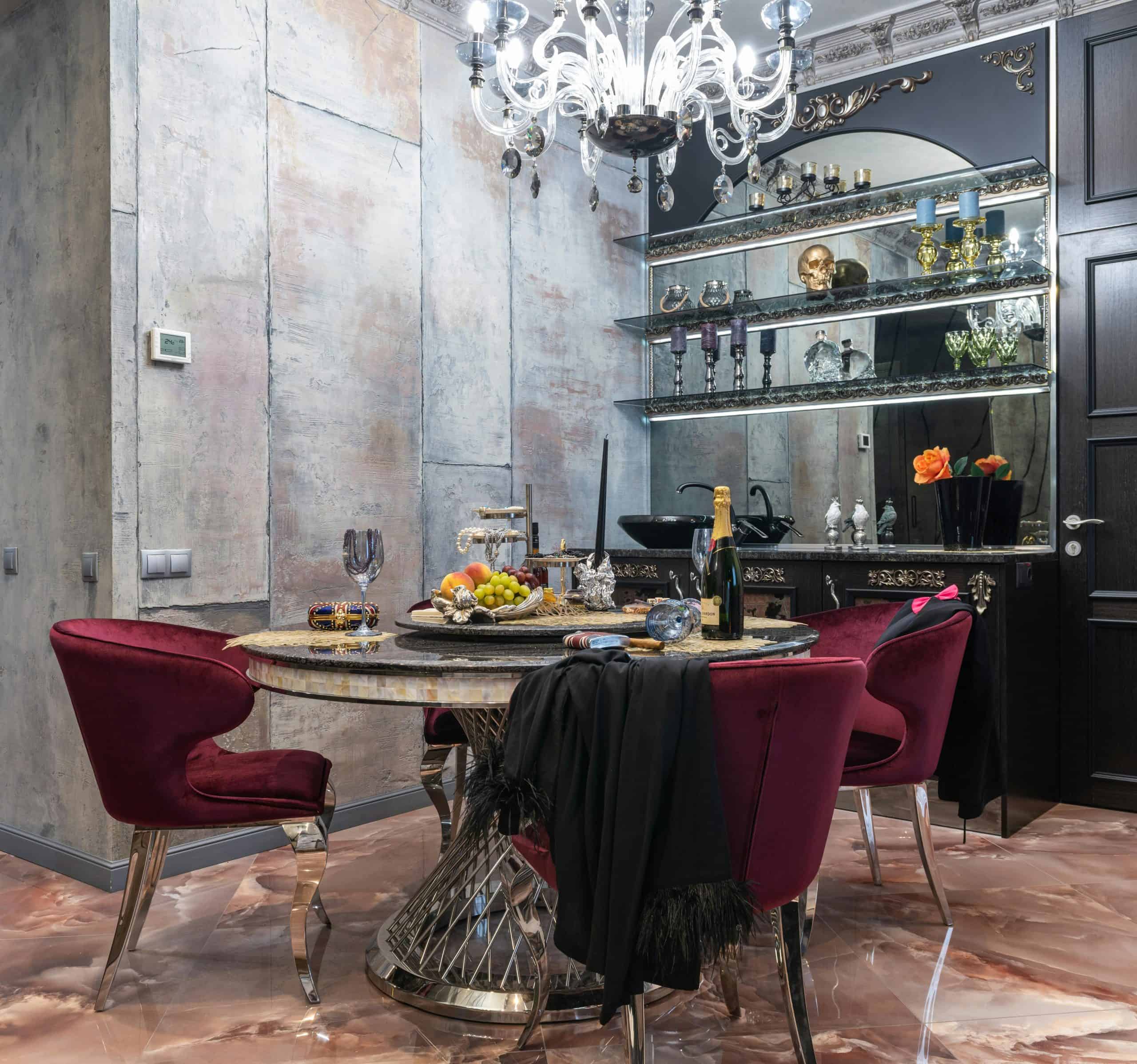 Opulent dining room with velvet chairs, chandelier, and decorative elements creating a luxurious atmosphere.