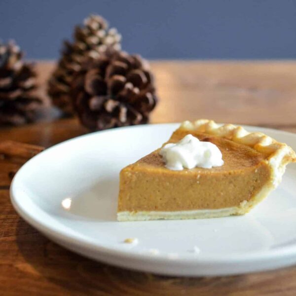 Close-up of a pumpkin pie slice with whipped cream, perfect for fall desserts. Costco